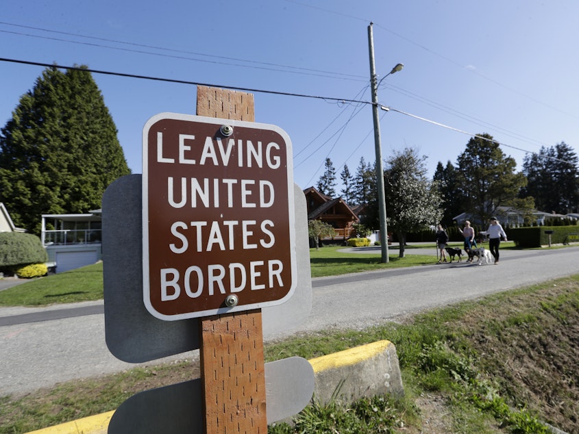 caption: Sign posted at the U.S.-Canada border.
