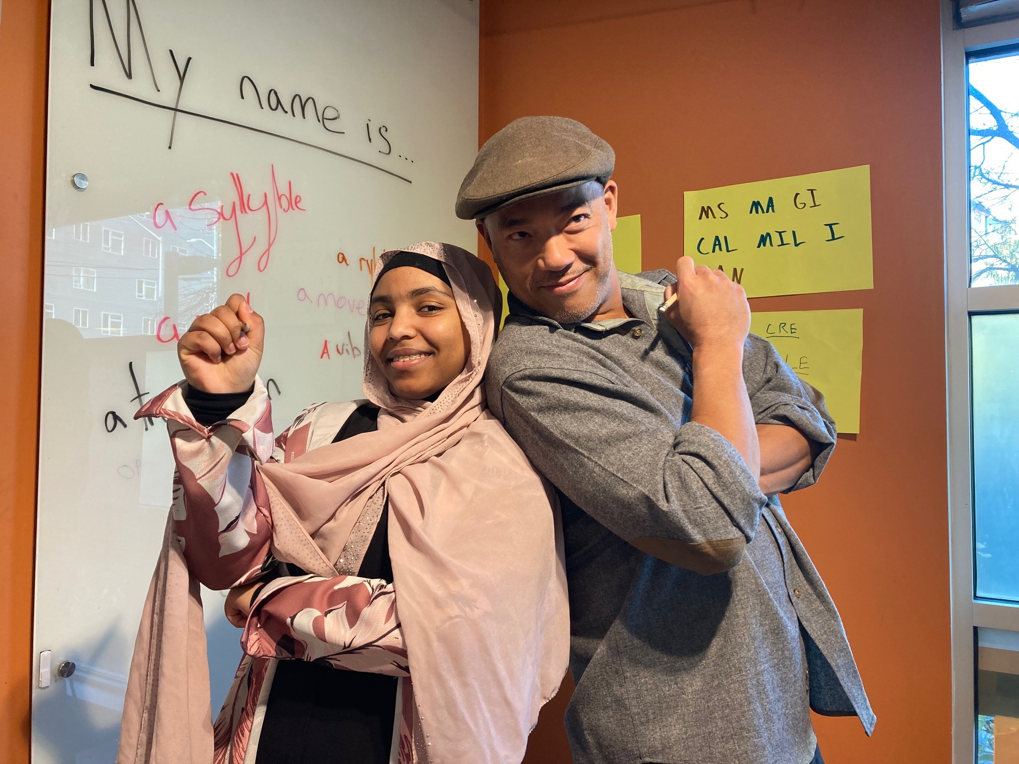 caption: Yasmin Mohammed (left) and Roberto Ascalon (right) pose in the corner of the Bureau of Fearless Ideas, in Beacon Hill.