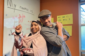 caption: Yasmin Mohammed (left) and Roberto Ascalon (right) pose in the corner of the Bureau of Fearless Ideas, in Beacon Hill.