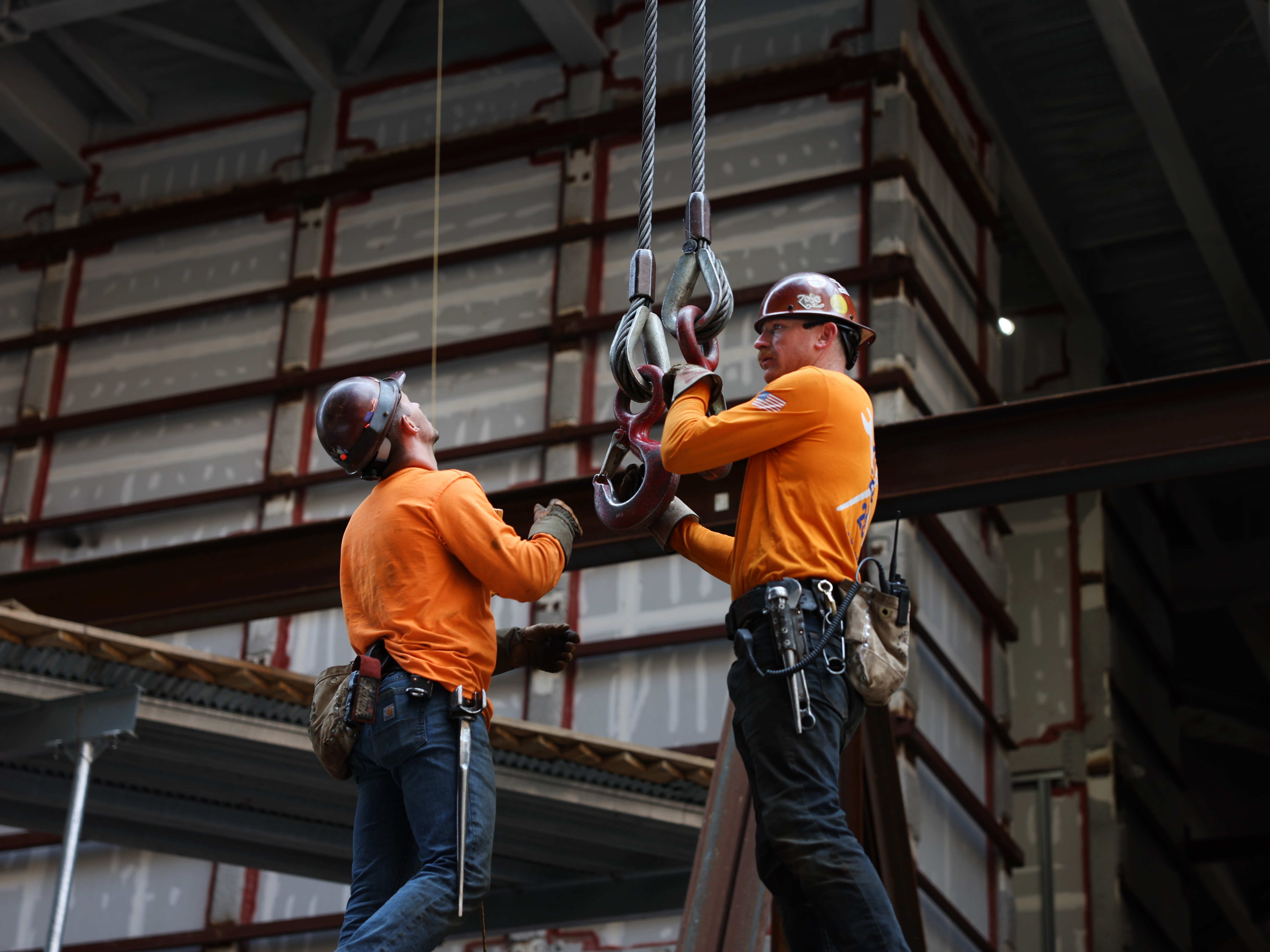 caption: Construction workers prepare steel for a crane at the site of JPMorgan Chase's new headquarters in New York City on May 18, 2023. Builders added jobs this month despite the headwinds from higher interest rates. It was another indication of the country's strong job market.