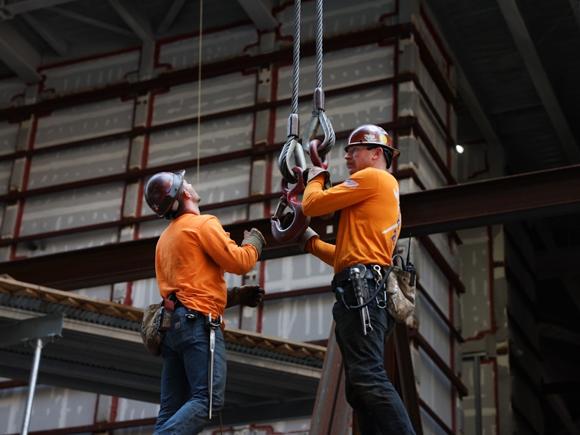 caption: Construction workers prepare steel for a crane at the site of JPMorgan Chase's new headquarters in New York City on May 18, 2023. Builders added jobs this month despite the headwinds from higher interest rates. It was another indication of the country's strong job market.