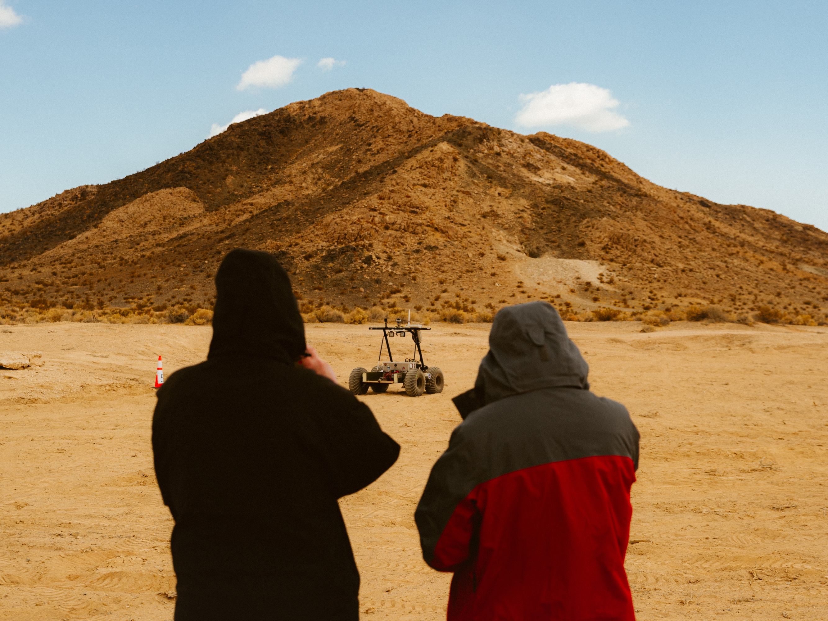 caption: Two people admiring the Helelani rover.
