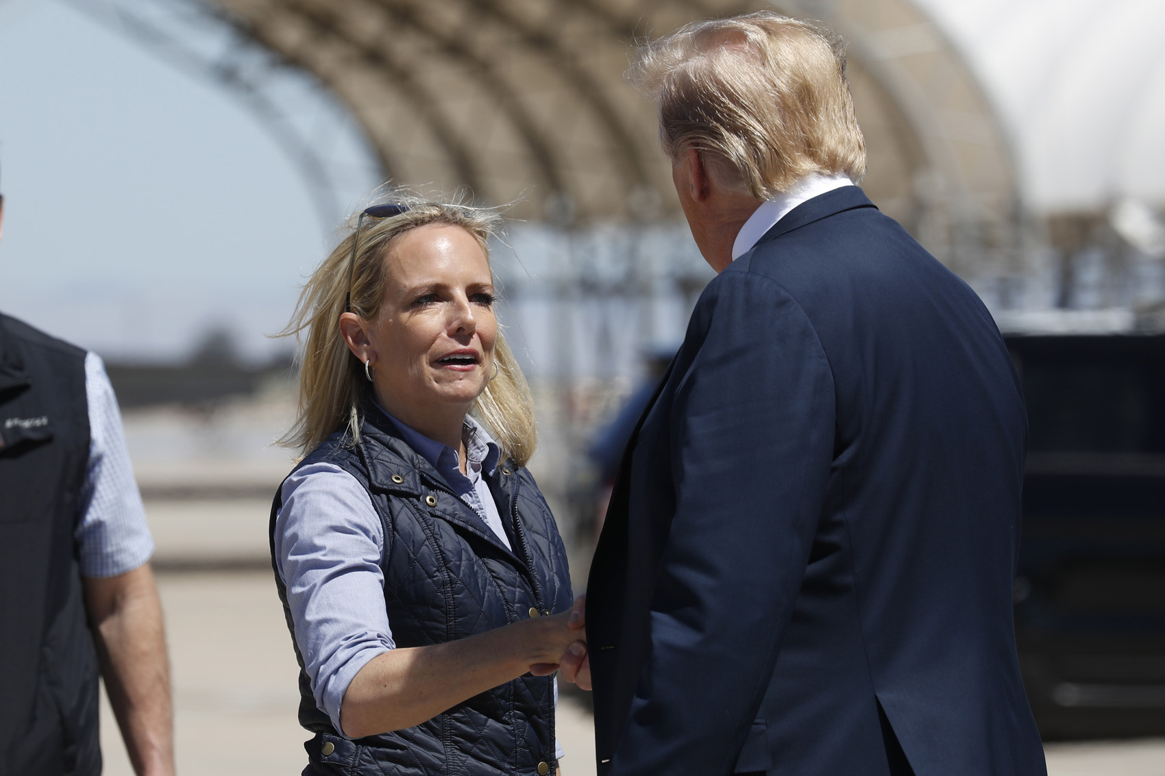 caption: President Donald Trump greets Homeland Security Secretary Kirstjen Nielsen after he arrived on Air Force One at Naval Air Facility El Centro, in El Centro, Calif., Friday April 5, 2019. (Jacquelyn Martin/AP)