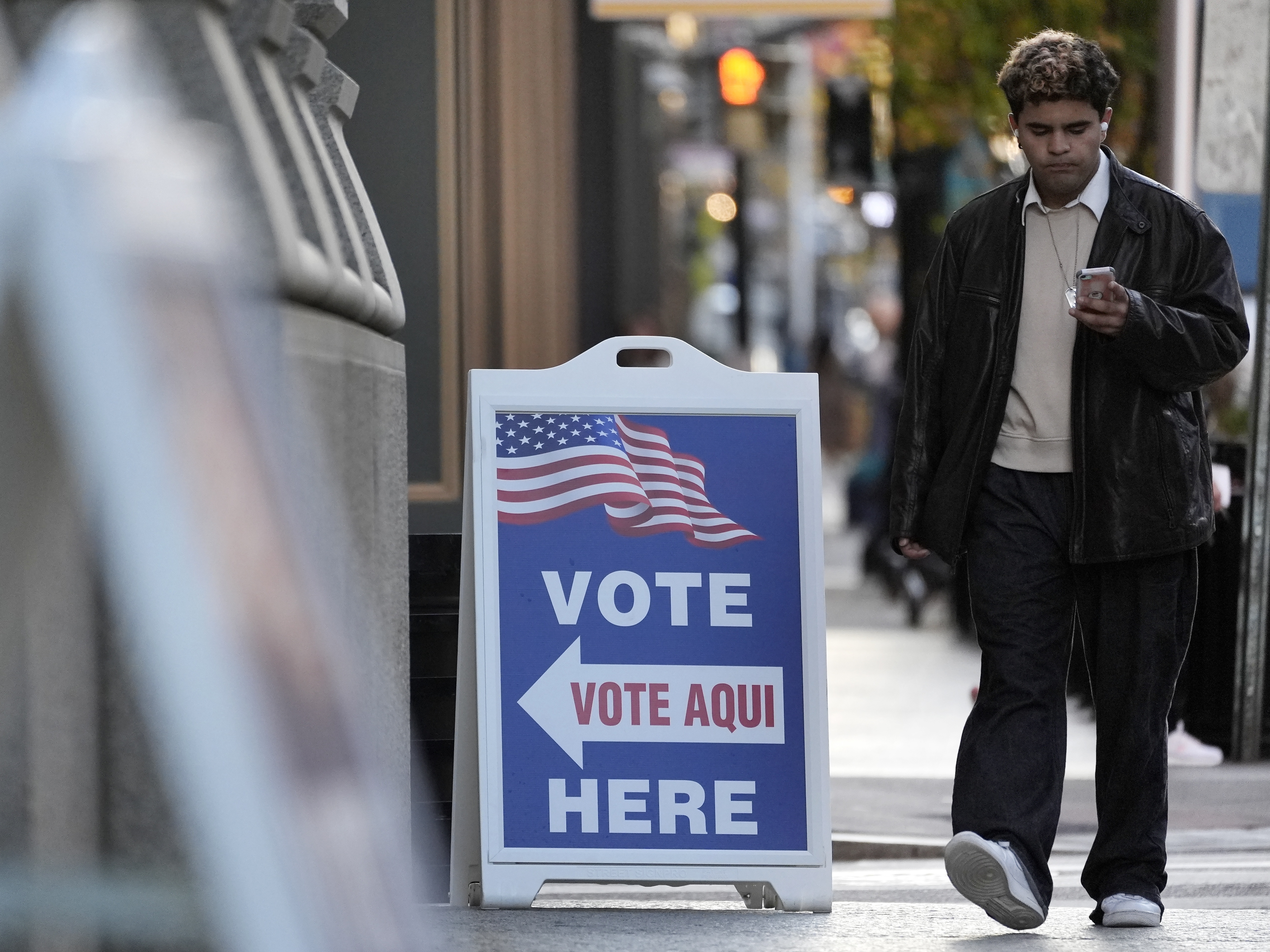 caption: A man walks past a polling place at City Hall in Providence, R.I., on Nov. 5, 2024.