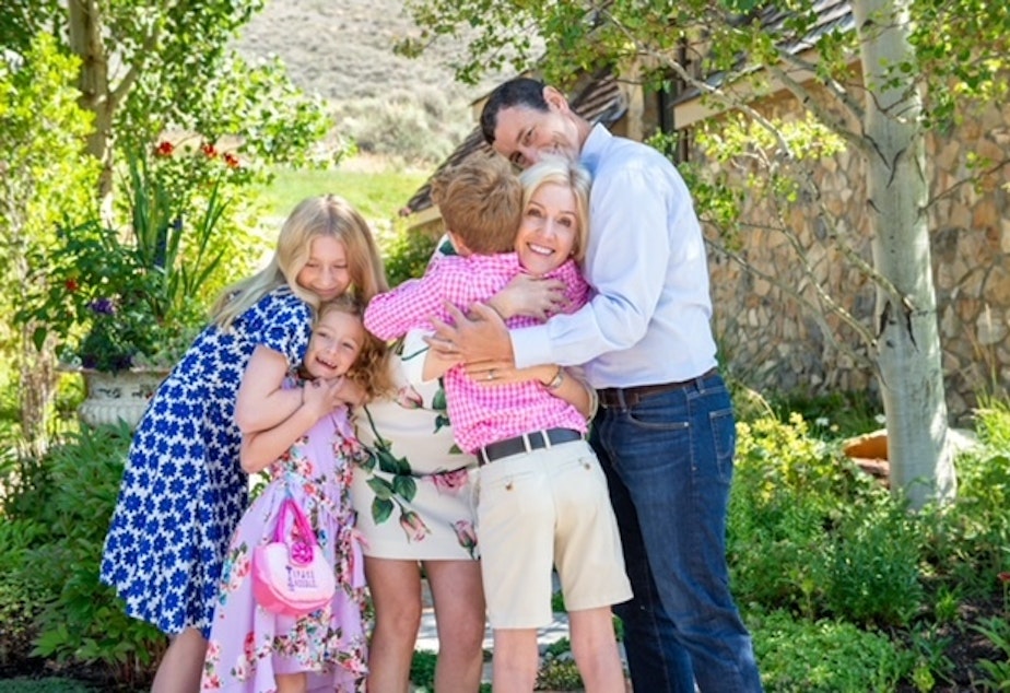 caption: Nicole McNichols (center) hugging her family. McNichols is a psychology professor of human sexuality at the University of Washington.