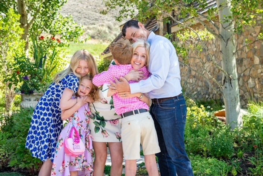 caption: Nicole McNichols (center) hugging her family. McNichols is a psychology professor of human sexuality at the University of Washington.