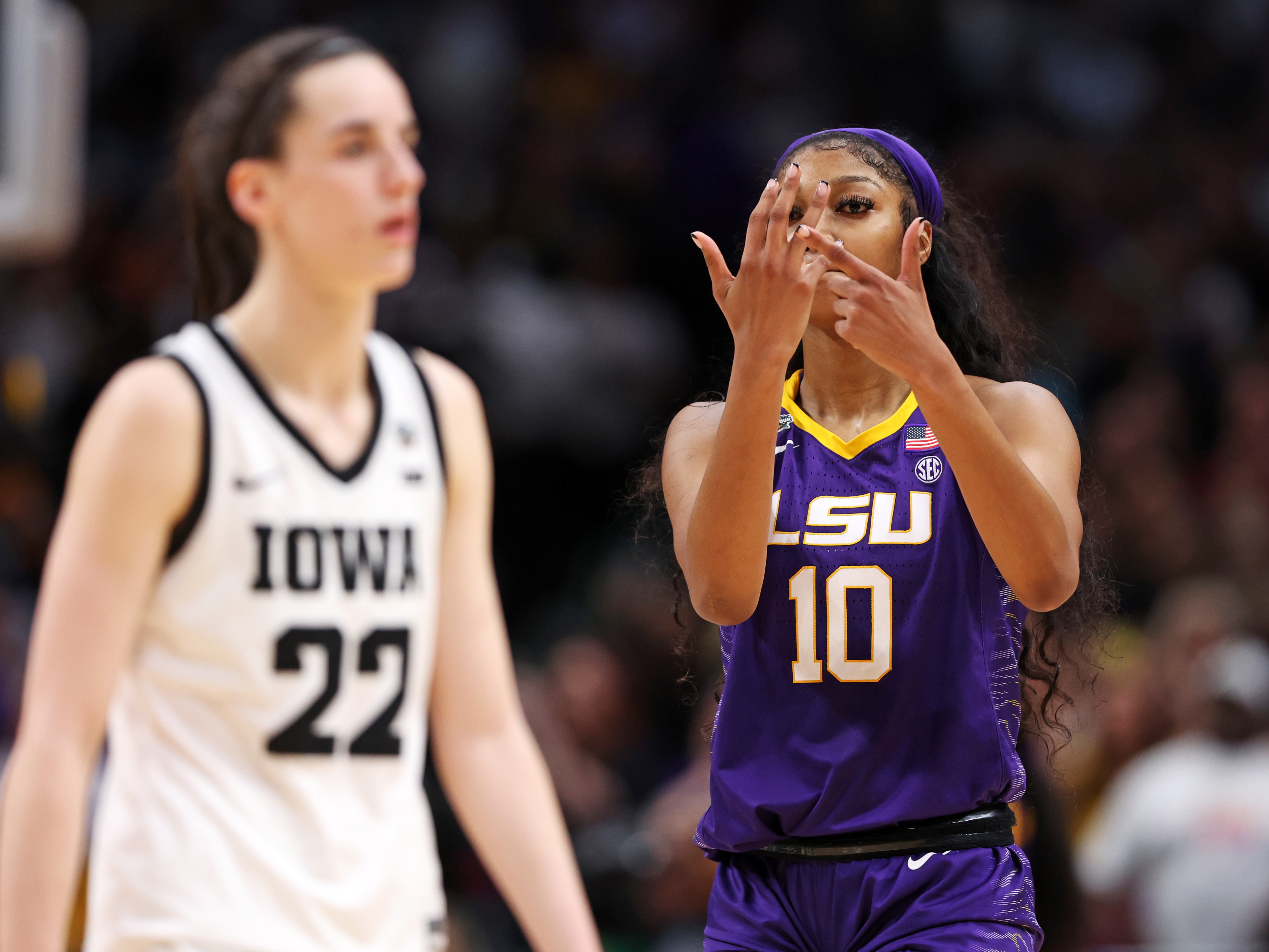 caption: Angel Reese of the LSU Tigers gestures towards Caitlin Clark of the Iowa Hawkeyes towards the end of the NCAA Women's Basketball Tournament championship game in Dallas on Sunday.
