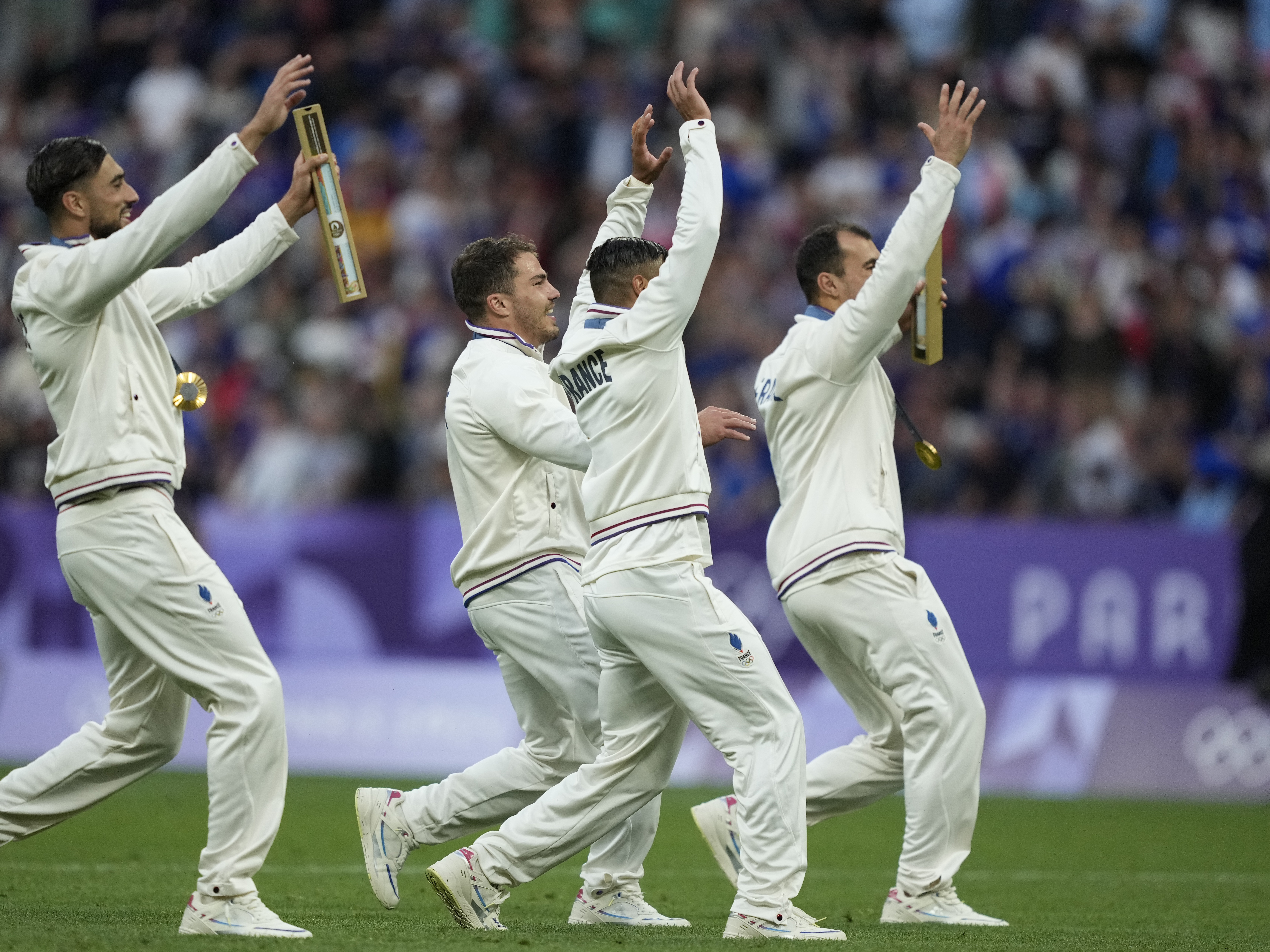 caption: Antoine Dupont of France, second left and teammates celebrate with their gold medal after defeating Fiji in the final of the men's Rugby Sevens at the 2024 Summer Olympics in France on Saturday.
