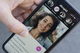 caption: A sample page on the OkCupid app is held for a photograph showing the "I'm vaccinated," checkmark, Friday, May 21, 2021, in Washington.