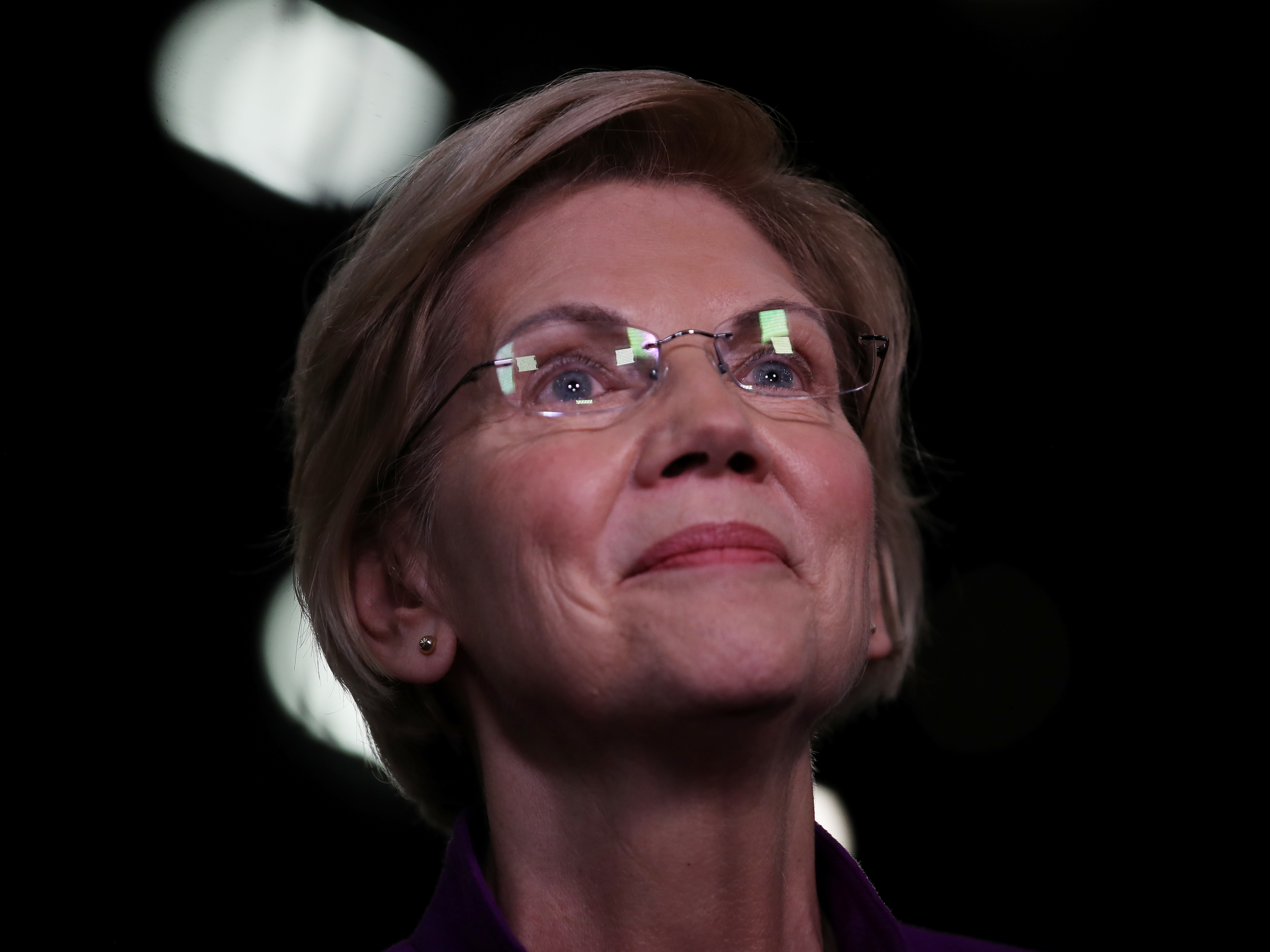 caption: Sen. Elizabeth Warren, D-Mass., speaks to the media in the spin room after the first night of the Democratic presidential debate in Miami last month.