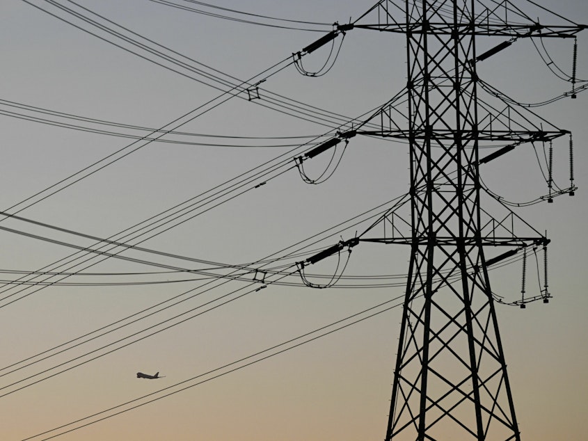 caption: Electric power lines are displayed at sunset in El Segundo, Calif., on Aug. 31, 2022. The FBI charged two men over attacks on Washington state's power grid that left thousands without power.