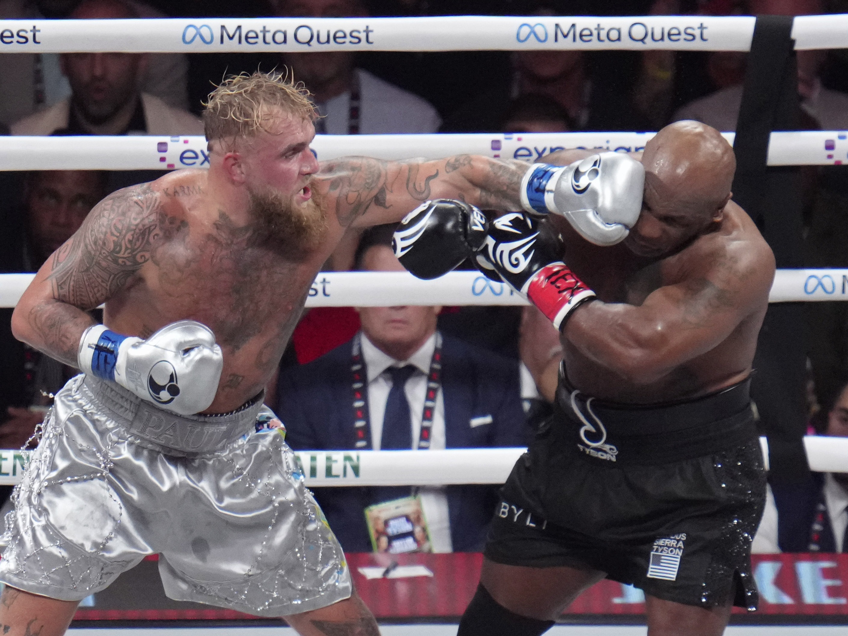 caption: Jake Paul lands a left to Mike Tyson during their heavyweight boxing match on Friday in Arlington, Texas.