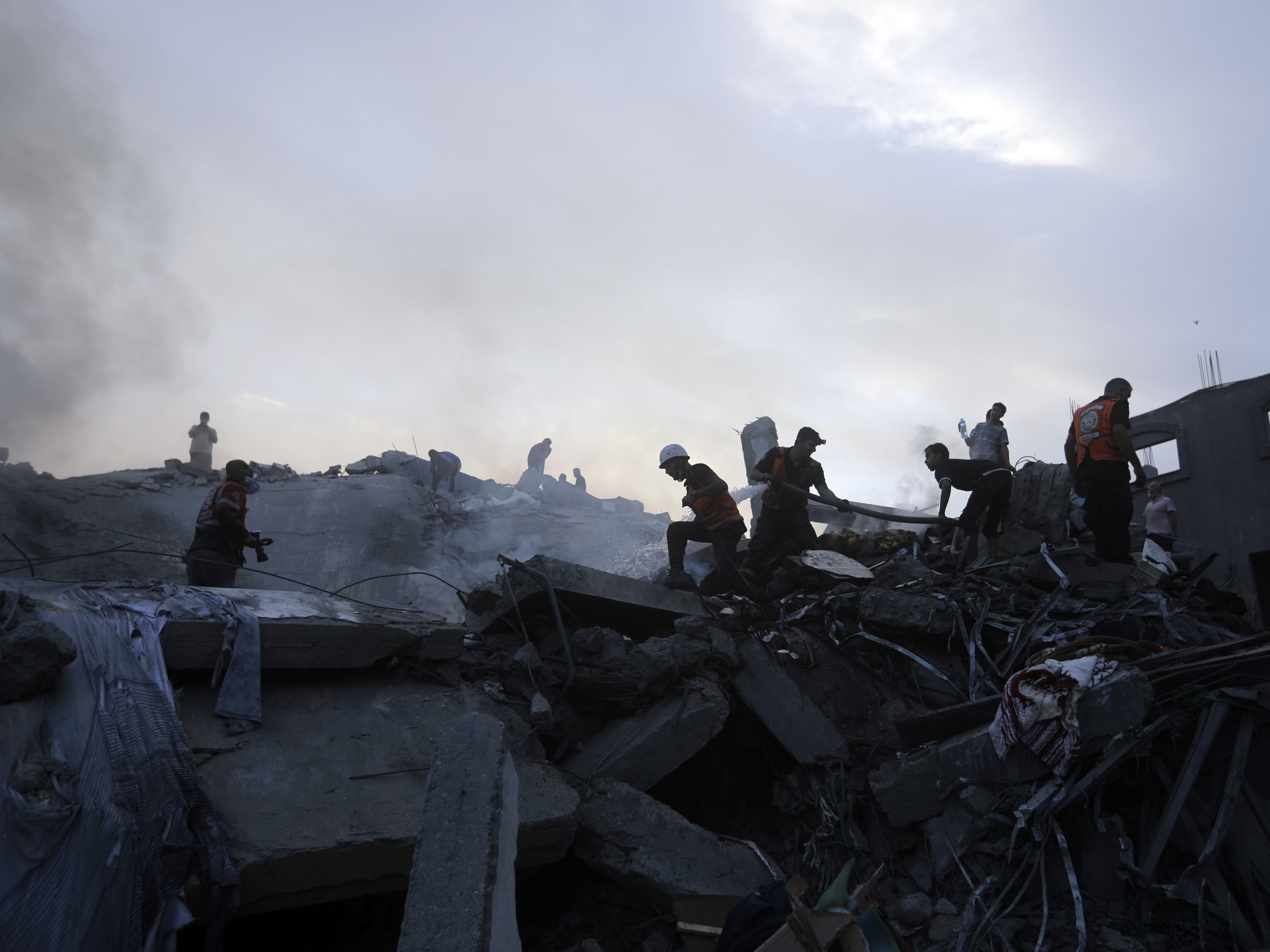 caption: Palestinians look for survivors under the rubble of a destroyed building following Israeli airstrikes in Nuseirat, central Gaza Strip, Oct. 31, 2023.