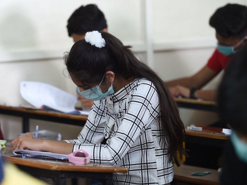 caption: Students sit for an exam in Ahmedabad, India, on Thursday. In the nation's capital, New Delhi, all primary schools have been ordered closed until March 31 due to coronavirus concerns.