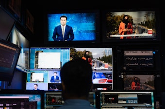 caption: A man works on the evening broadcast from TOLOnews, Afghanistan's first 24/7 new channel.