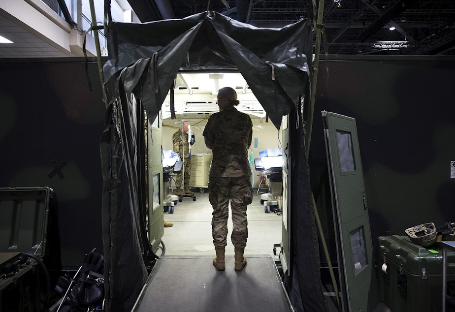caption: U.S. Army soldiers are shown in the operating room of a military field hospital set up by soldiers from the 627th Army Hospital from Fort Carson, Colorado, as well as from Joint Base Lewis-McChord on Tuesday, March 31, 2020, at the CenturyLink Field Event Center in Seattle. The 250-bed hospital will be for non COVID-19 patients.