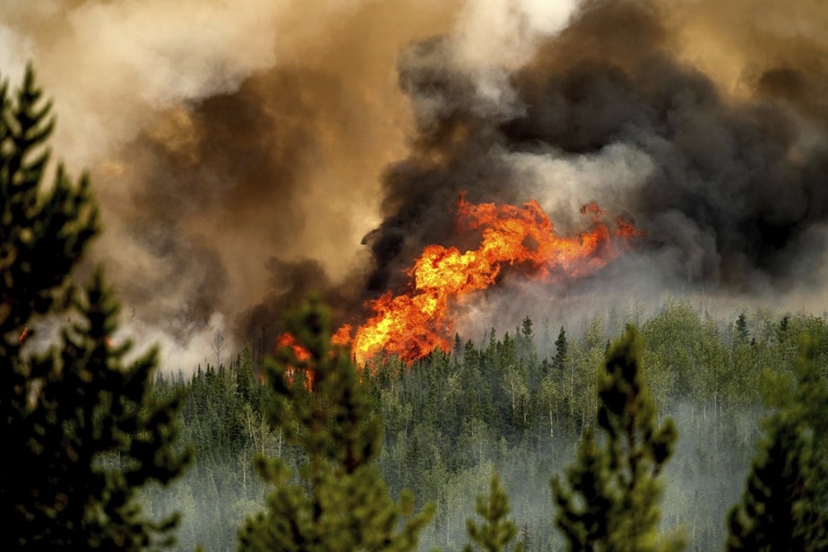 caption: Flames from the Donnie Creek wildfire burn along a ridge top north of Fort St. John, British Columbia, Canada, Sunday, July 2, 2023.