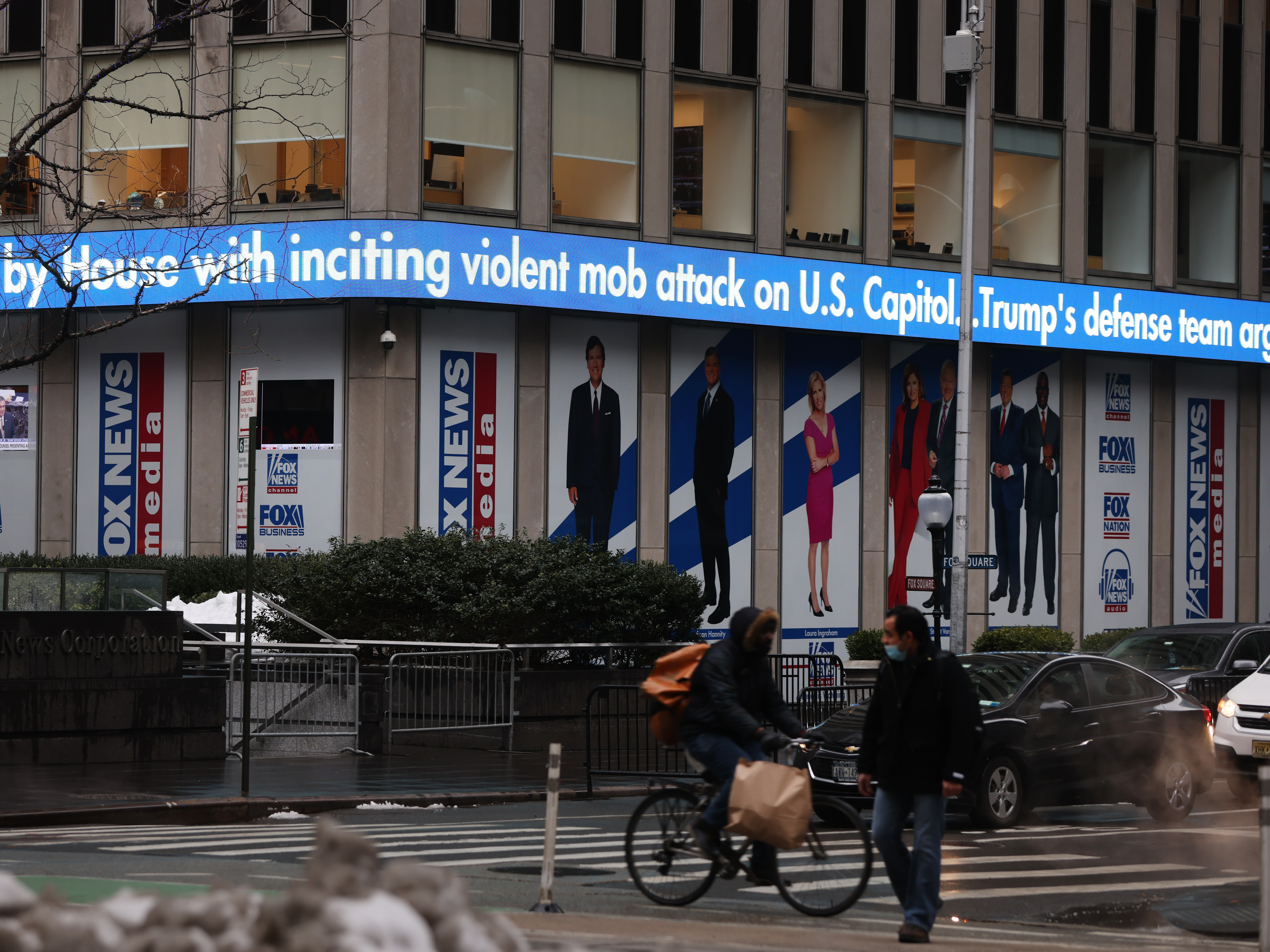 caption: News headlines on the impeachment trial of Donald Trump are displayed outside Fox headquarters in February in New York City.