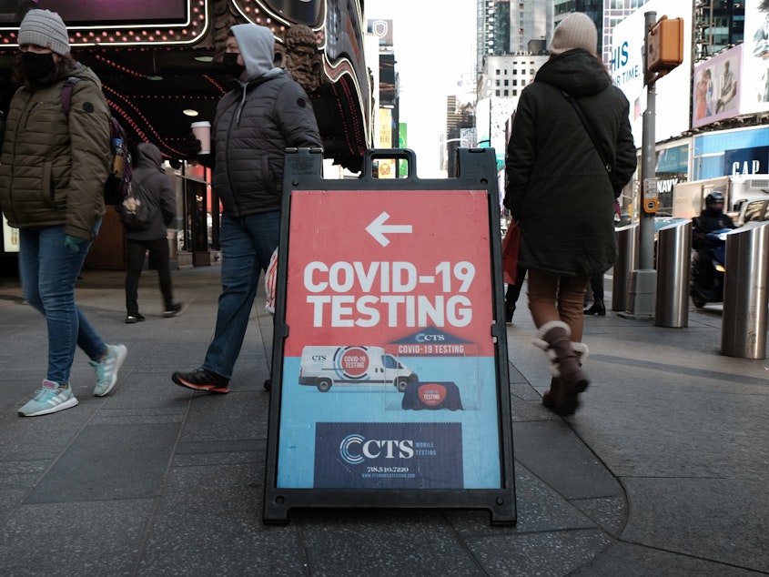 caption: People pass a COVID-19 testing site on a Manhattan street on Jan. 21. The White House says it is running out of money to pay for COVID tests for people who don't have insurance.