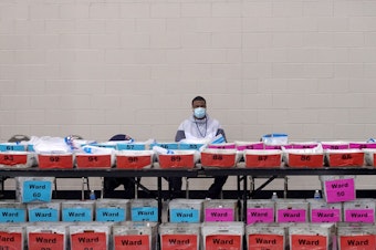caption: An election official pauses during the ballot recount earlier this month at the Wisconsin Center in Milwaukee. Officials in Milwaukee County, where President Trump had demanded a recount, said that Joe Biden's lead increased slightly on review.