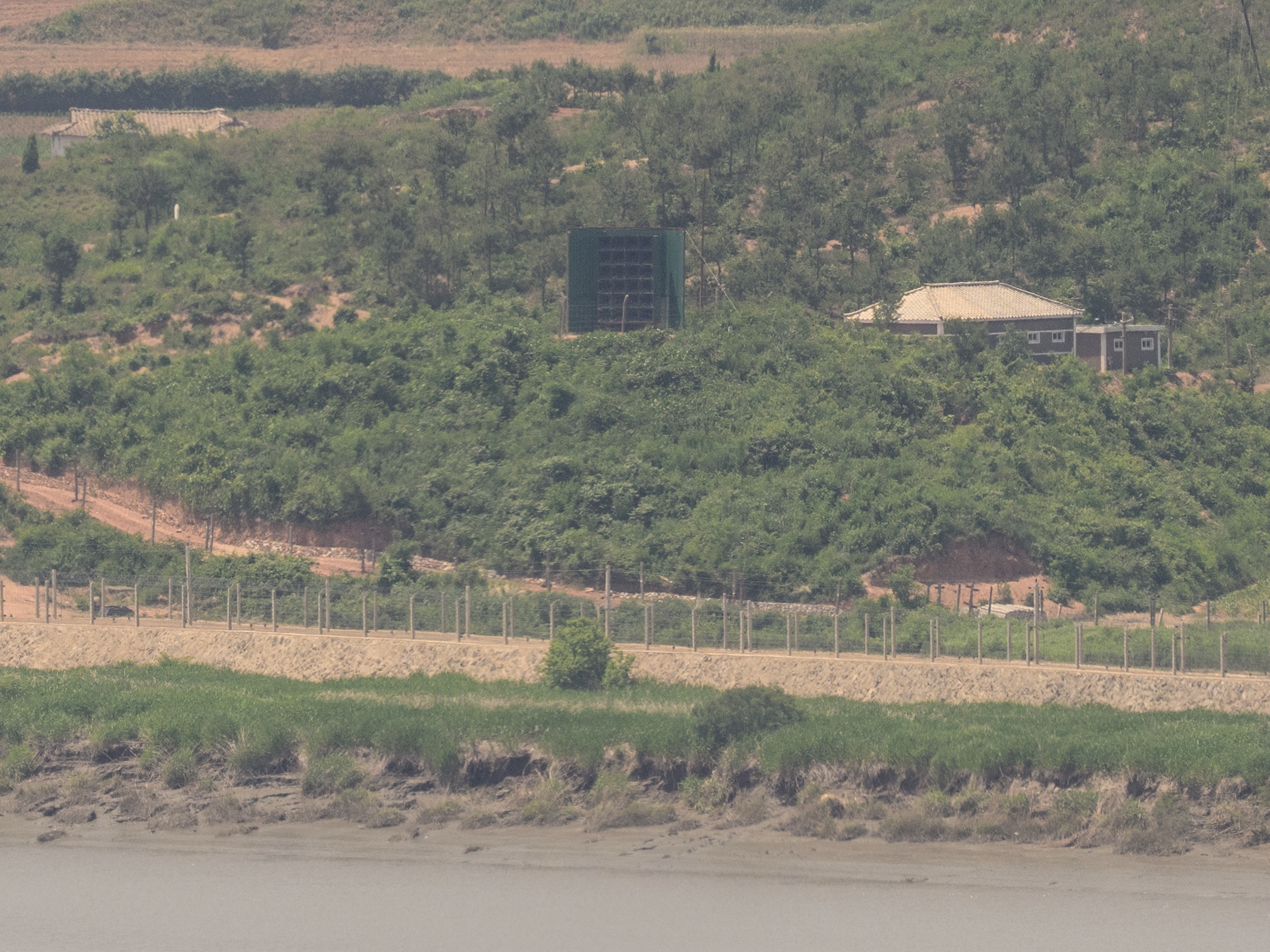 caption: This photo shows a general view of a North Korean giant loudspeaker (C), near the Demilitarized Zone (DMZ) dividing the two Koreas, in Paju on June 12, 2025.