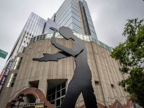 caption: "The Hammering Man" stands in front of the entrance to the Seattle Art Museum in downtown Seattle. 