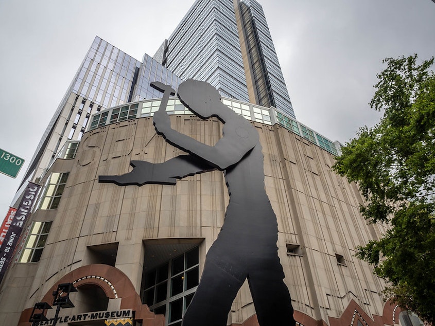 caption: "The Hammering Man" stands in front of the entrance to the Seattle Art Museum in downtown Seattle.