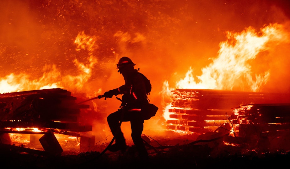 caption: A firefighter douses flames as they push towards homes during the Creek fire in the Cascadel Woods area of unincorporated Madera County, California on September 7, 2020.(JOSH EDELSON/AFP via Getty Images)