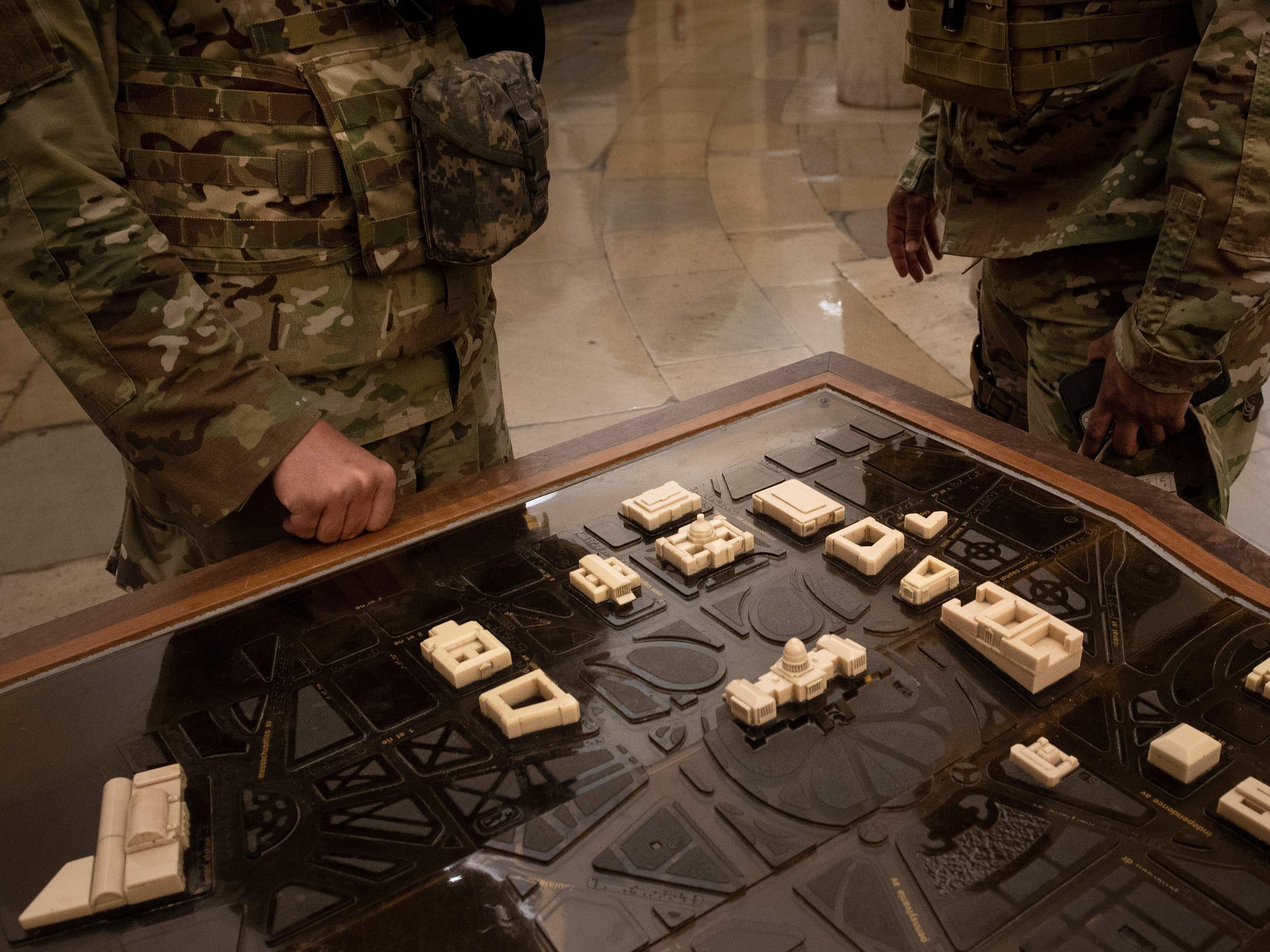 caption: National Guard members examine a terrain model of Capitol Hill on Thursday. U.S. Capitol Police requested the guardsmen stay another two months after threats of further  violence emerged.