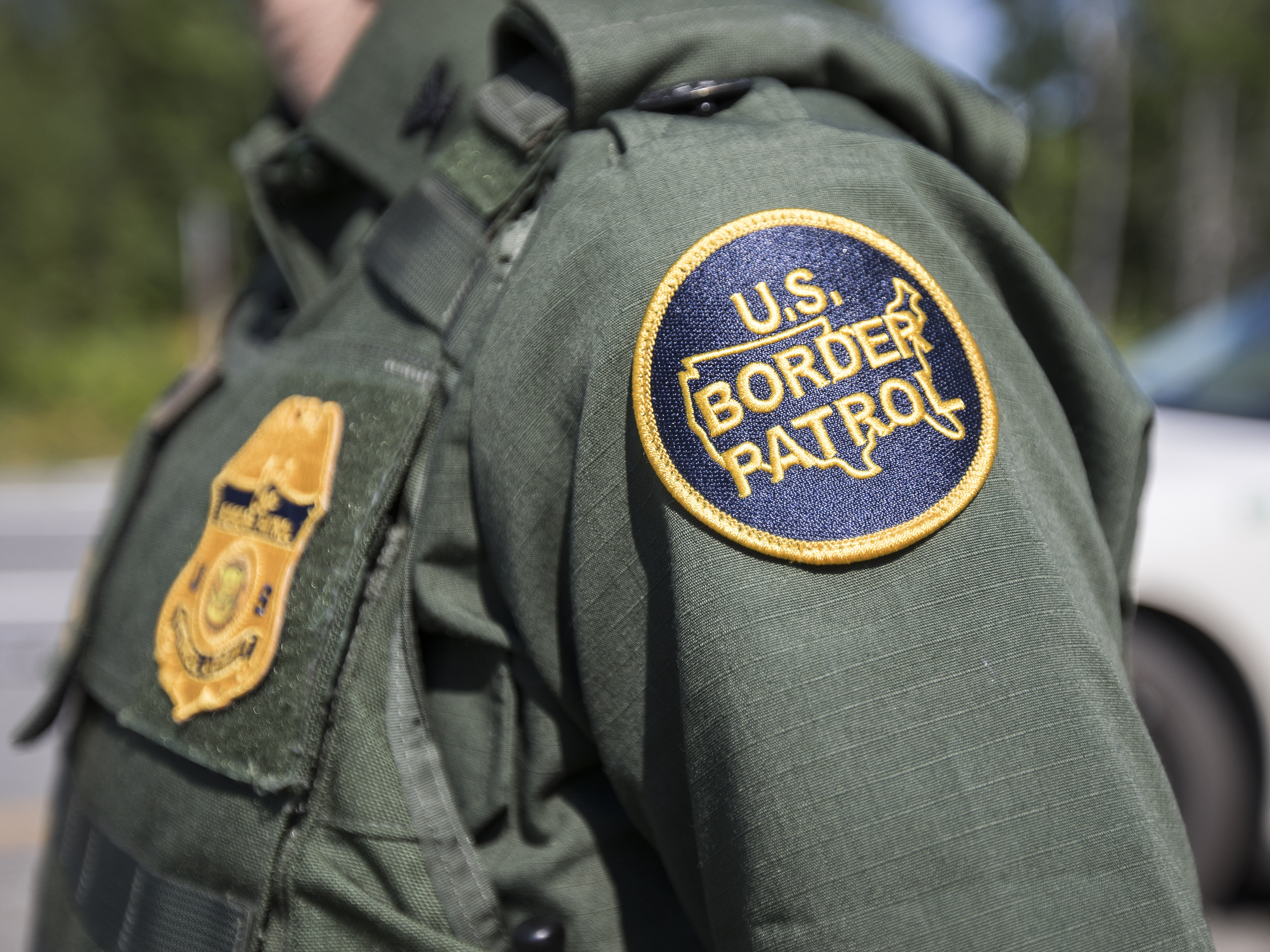 caption: A U.S. Border Patrol agent stands at a highway checkpoint on August 1 in West Enfield, Maine.