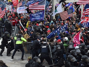 caption: Rioters clash with police as they push barricades to storm the U.S. Capitol on Jan. 6, 2021.