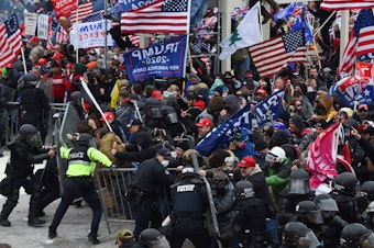 caption: Rioters clash with police as they push barricades to storm the U.S. Capitol on Jan. 6, 2021.