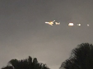 caption: This image taken from video provided by Melanie Adaros shows what she said were sparks shooting from a cargo plane before it made an emergency landing at Miami International Airport on Thursday.