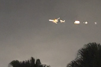 caption: This image taken from video provided by Melanie Adaros shows what she said were sparks shooting from a cargo plane before it made an emergency landing at Miami International Airport on Thursday.