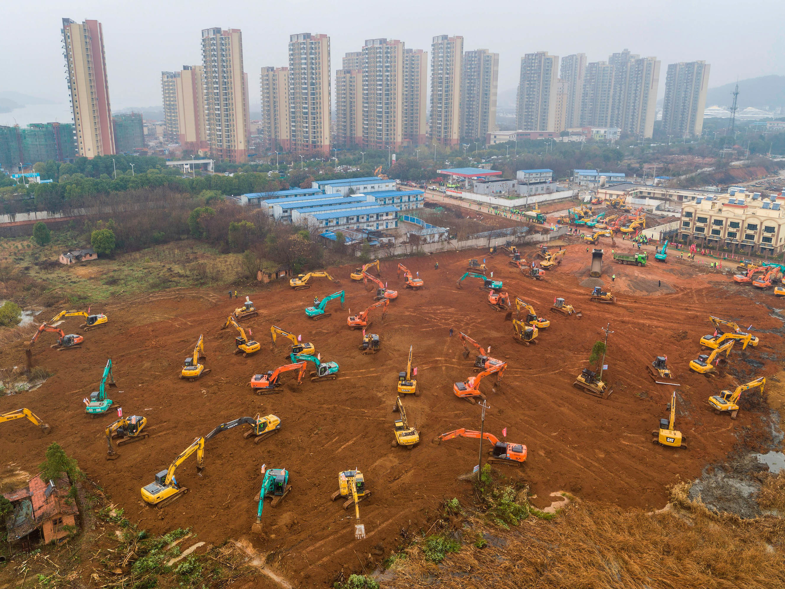 caption: Excavators are seen at the construction site of a medical center being built in Wuhan, China, to treat patients of the coronavirus outbreak. Ground was broken on Jan. 24. The scheduled opening is Feb. 3.