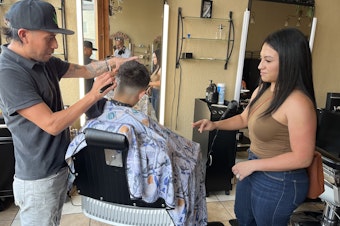 caption: Jennifer Nuno checks her 11-year-old son's back-to-school haircut in the Lincoln Village neighborhood of Milwaukee on August 21.