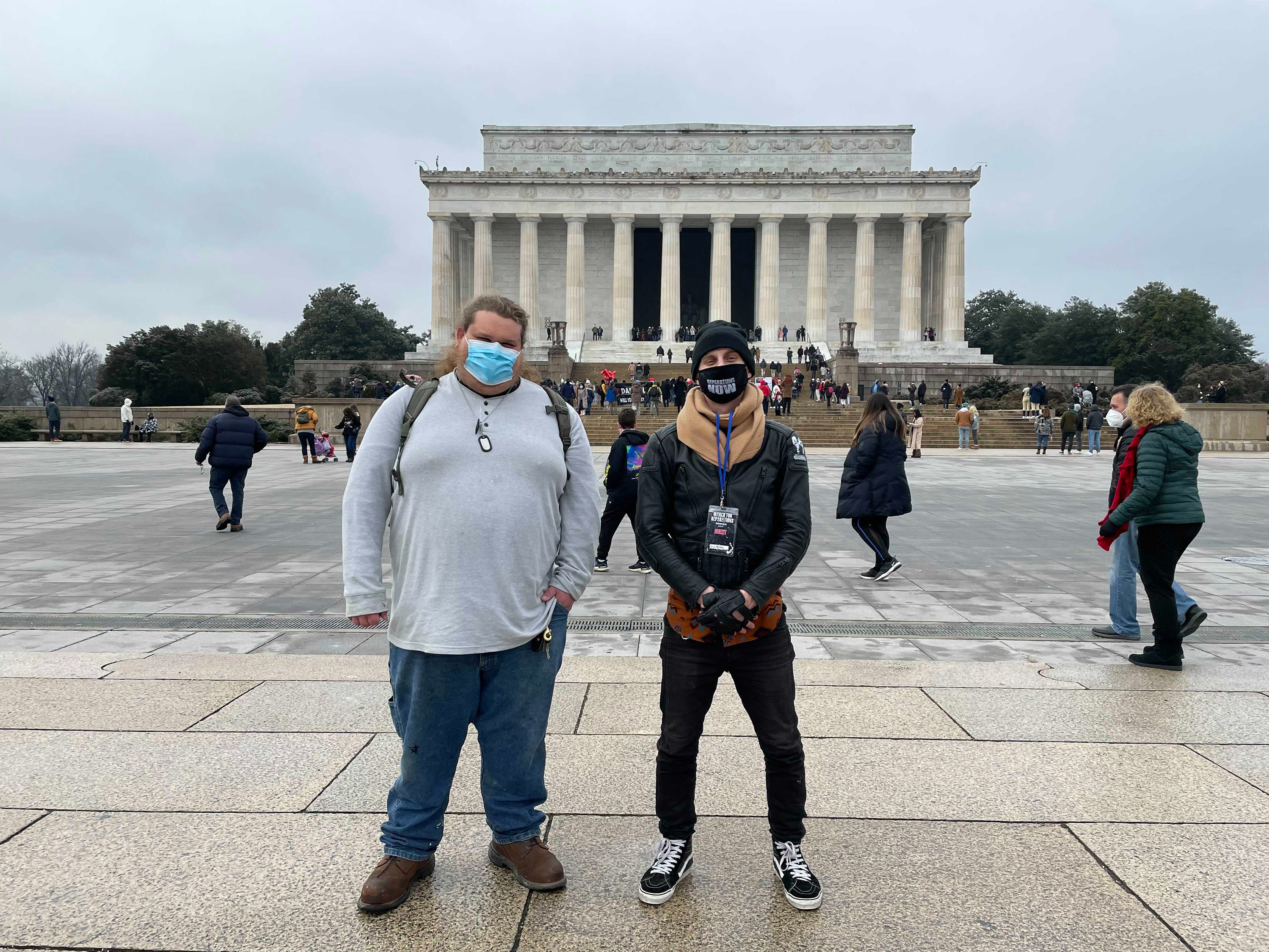 caption: Distant cousins Cody (left) and Andrew meet in Washington, D.C. Cody is a member of a Three Percenter-affiliated militia group, and Andrew is an organizer with Black Lives Matter activists. The two connected on Facebook and have gotten to know each other while researching their ancestry.