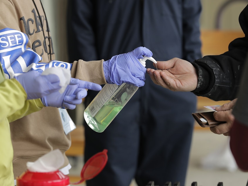 caption: A patient arrives to pick up medication for opioid addiction and is given hand sanitizer at a clinic in Olympia, Wash. The pandemic is changing the distribution networks and supplies of street drugs across the U.S., authorities say.