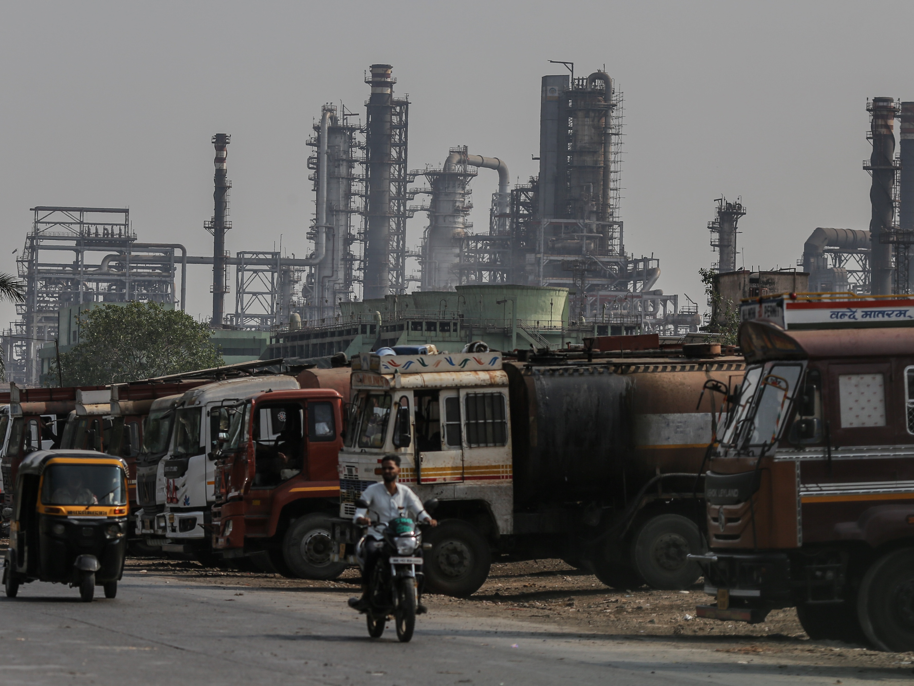 caption: Oil tanker trucks sit outside an oil refinery operated by Bharat Petroleum Corp. Ltd. in Mumbai, India.