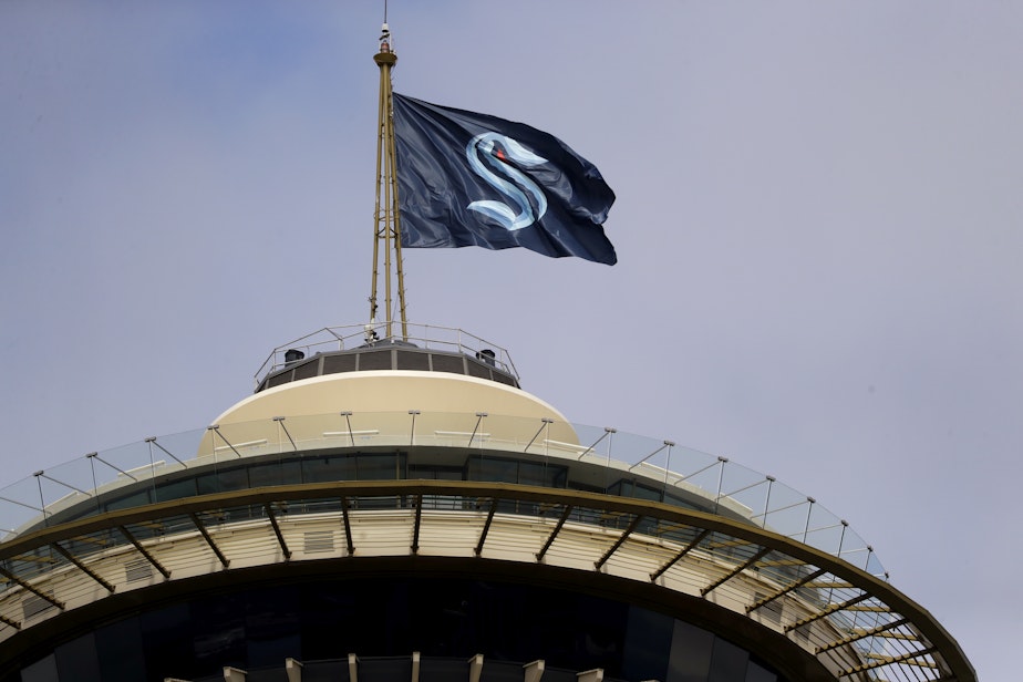 caption: A flag with the new logo for the newly-named Seattle NHL team, the Seattle Kraken, flies atop the iconic Space Needle Thursday, July 23, 2020, in Seattle. 