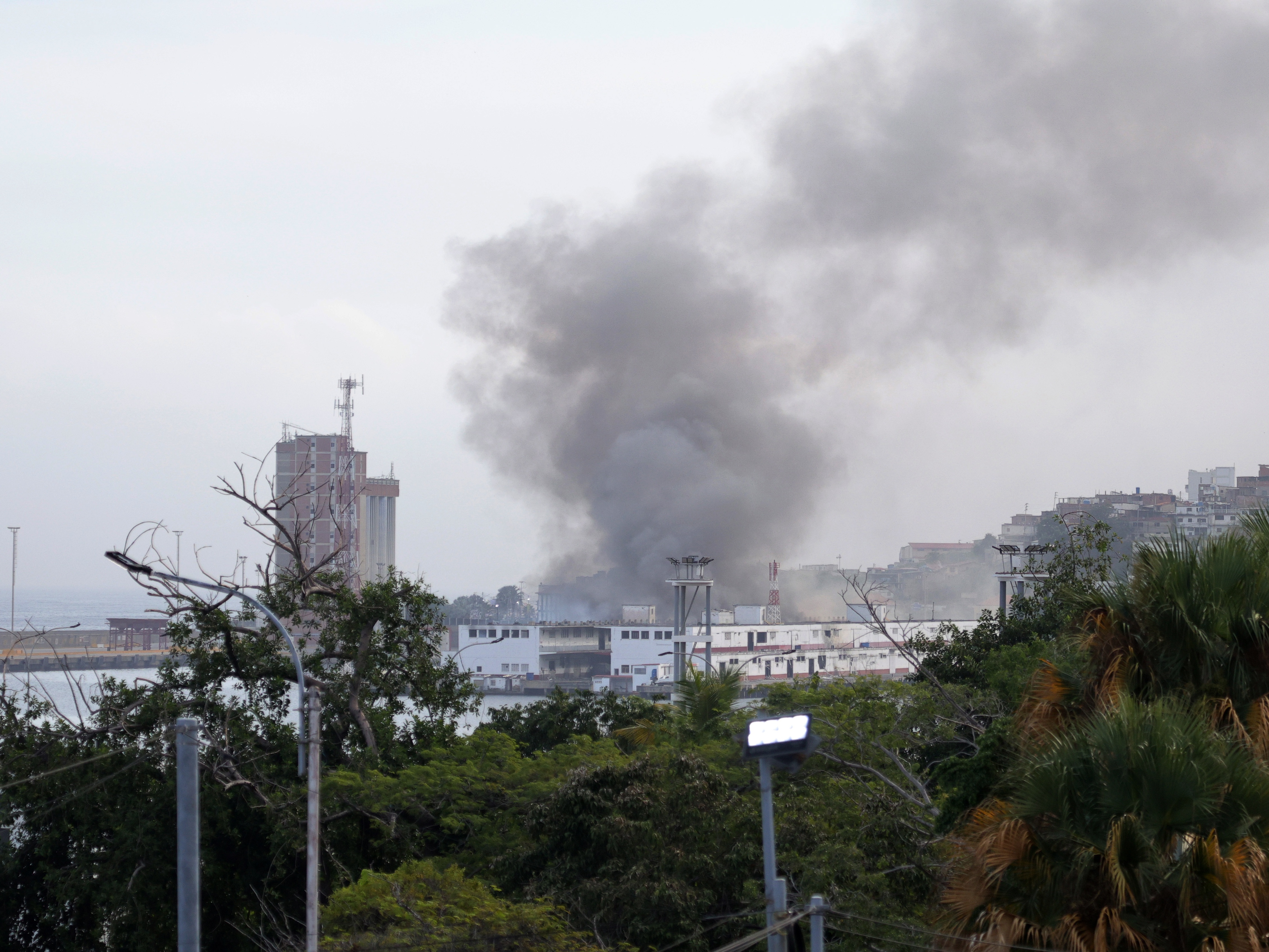 caption: Smoke rises from Port of La Guaira in Venezuela on Jan. 3, 2026 after U.S. forces seized the country's president, Nicolas Maduro, and his wife.