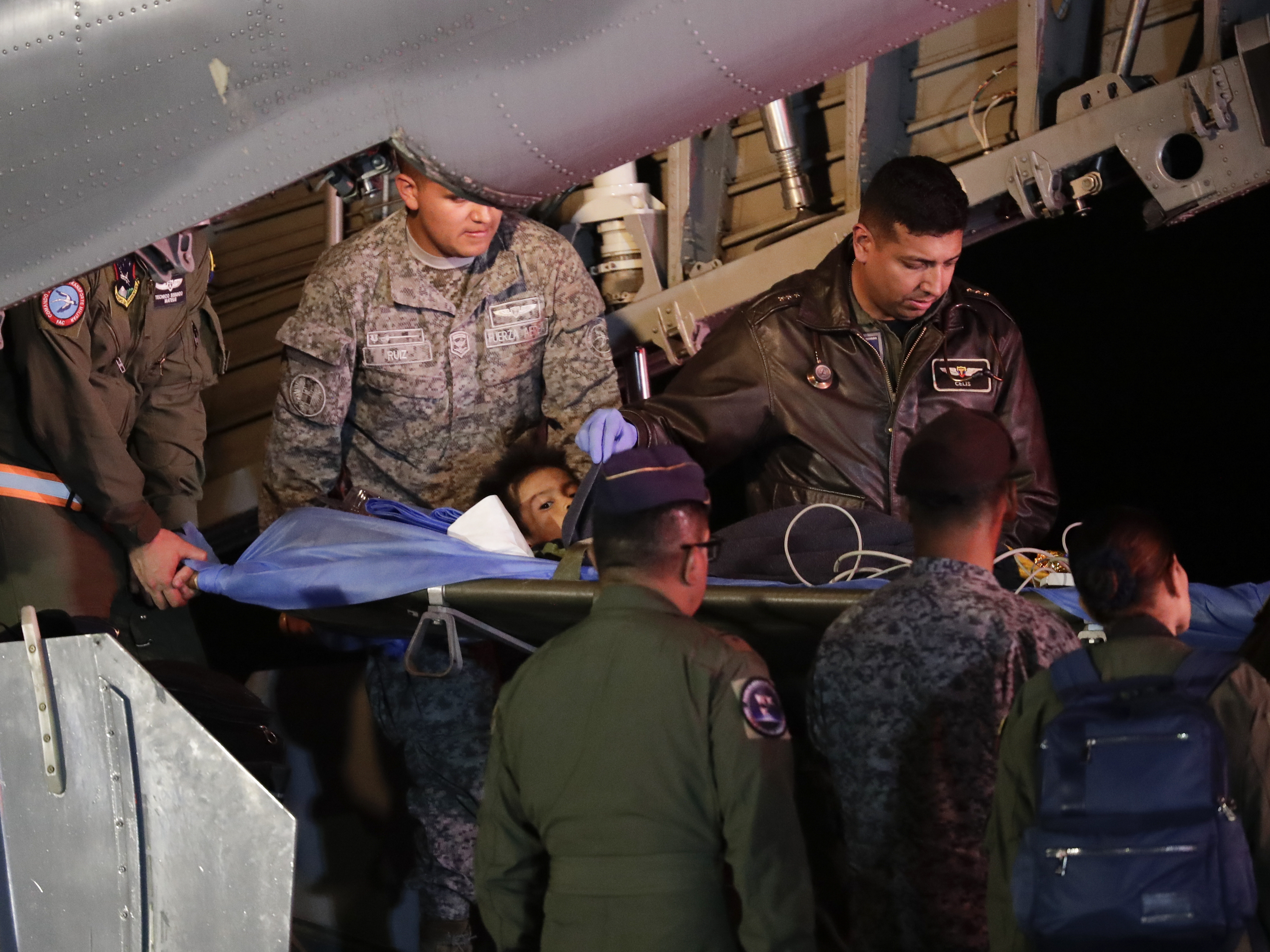 caption: On Saturday in Bogota, Colombia, military personnel unload from a plane one of four Indigenous children who were missing after a deadly plane crash.