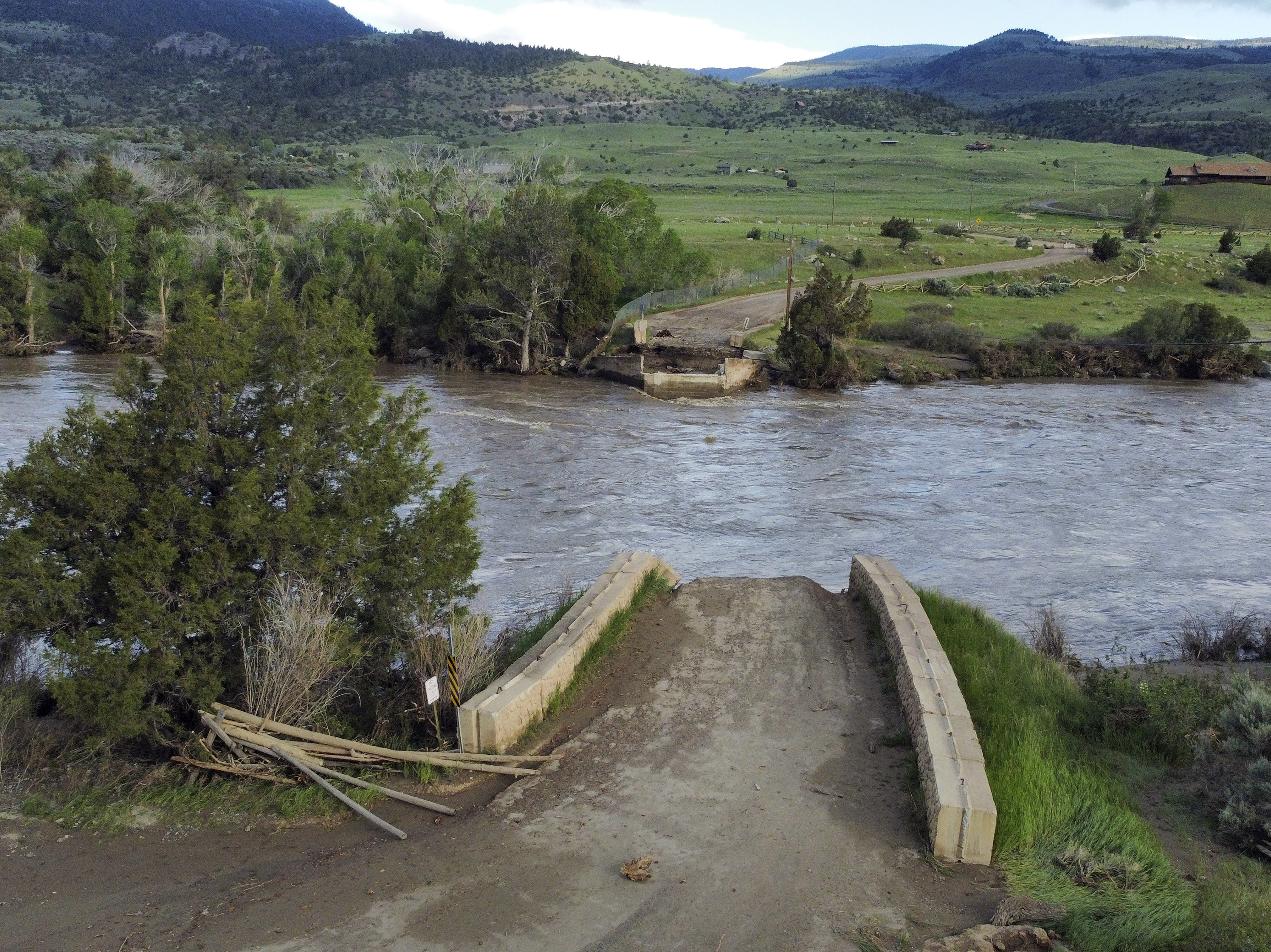 caption: A washed out bridge shown along the Yellowstone River Wednesday, June 15, 2022, near Gardiner, Mont.