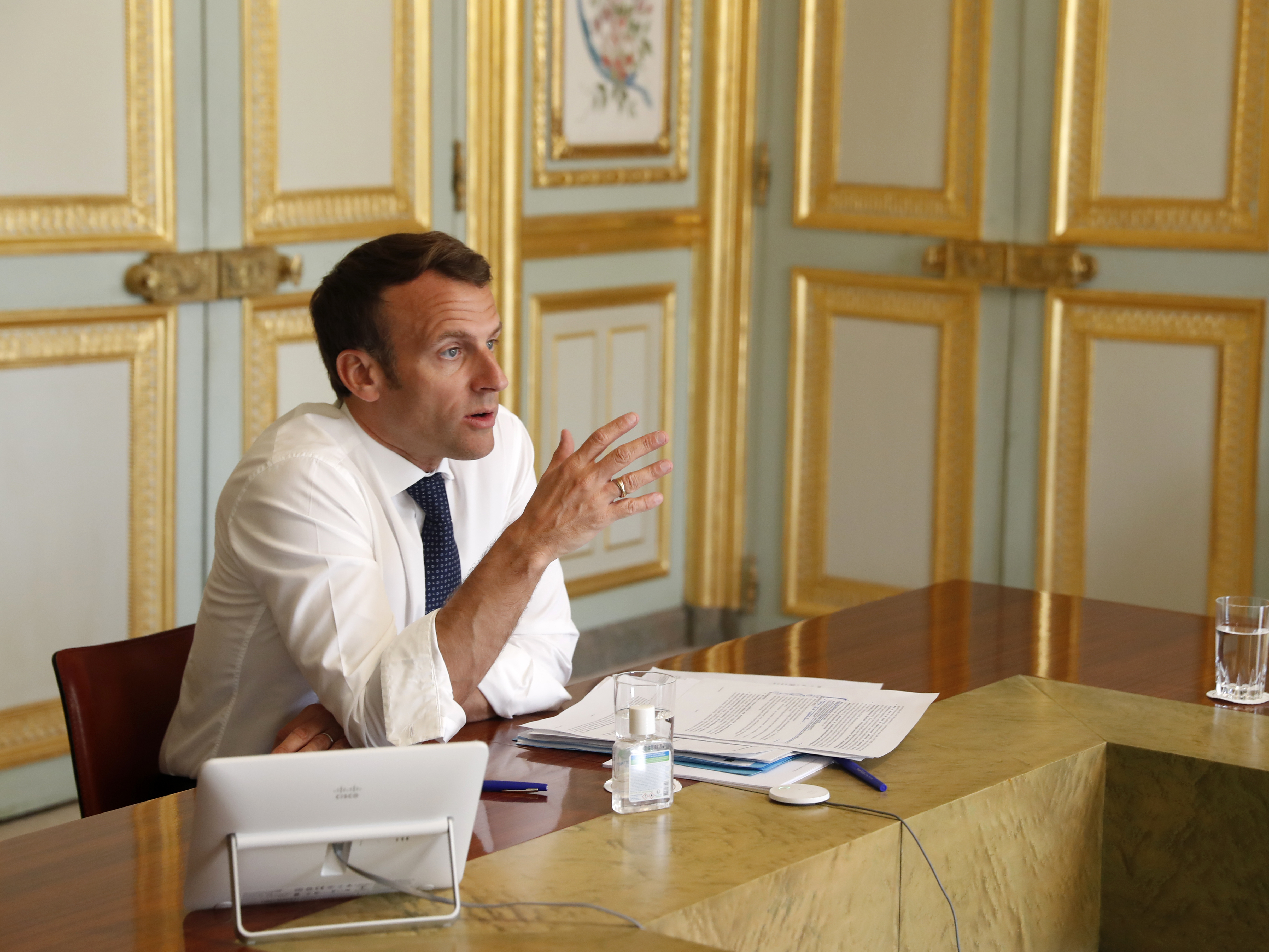 caption: French President Emmanuel Macron attends a video conference call with French virologist Françoise Barré-Sinoussi on efforts to develop a vaccine and treatment against the new coronavirus, at the Elysee Palace in Paris, Thursday.