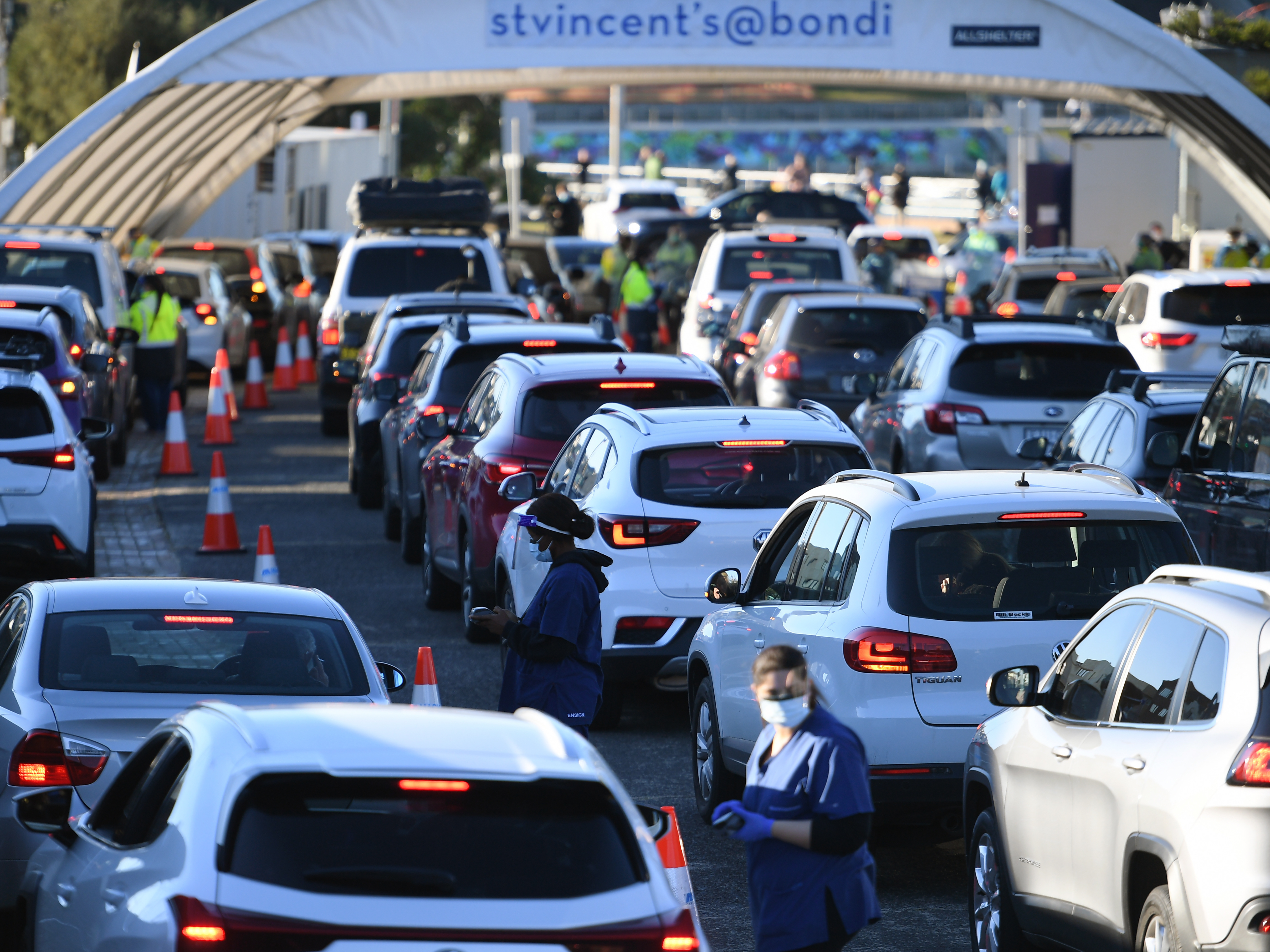 caption: People line up in their cars to get tested for COVID-19 at a pop-up testing clinic at Bondi Beach in Sydney on Friday. Parts of Sydney will go into lockdown late Friday because of a growing coronavirus outbreak in Australia's largest city.