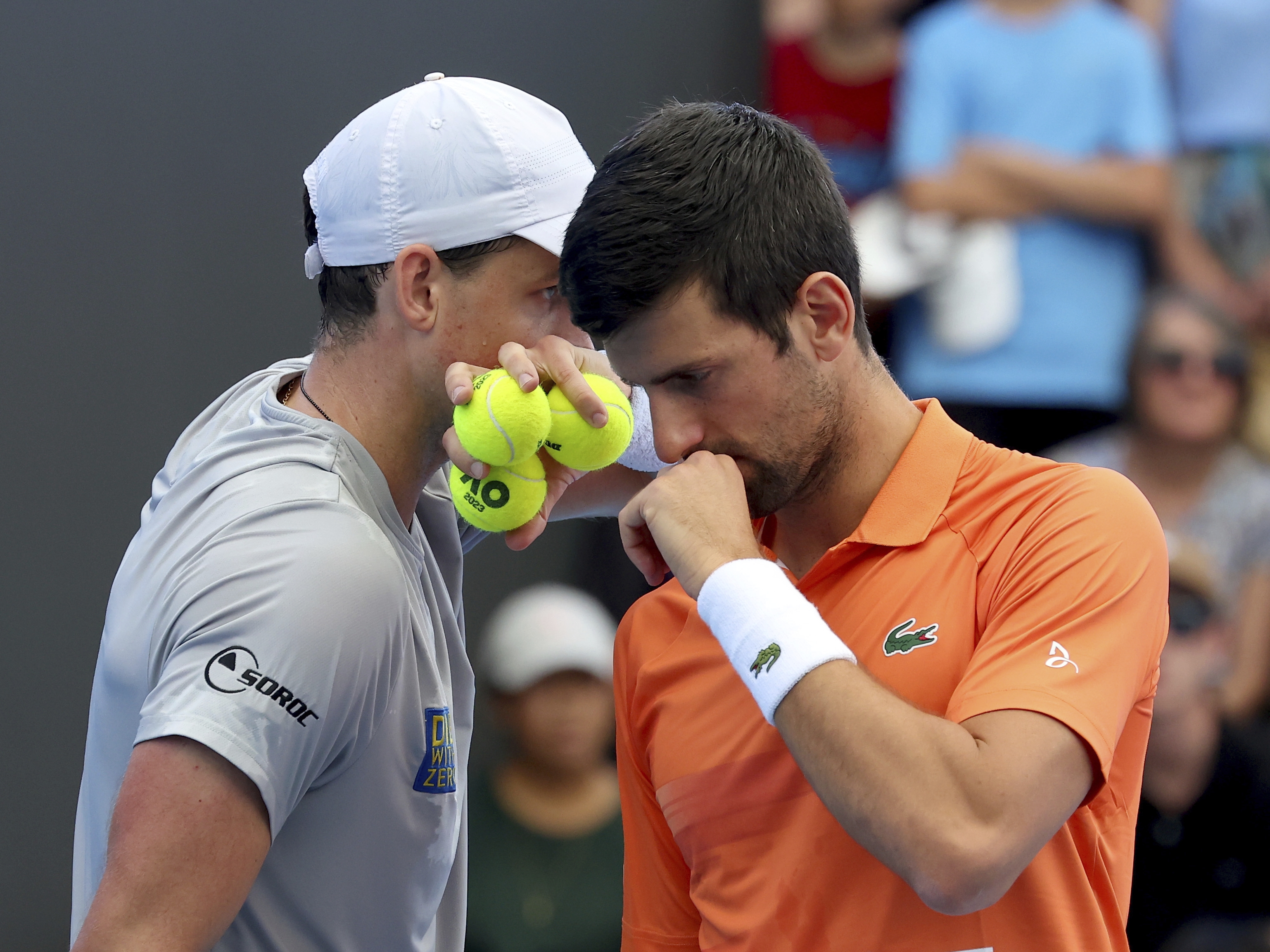 caption: Canada's Vasek Pospisil and Serbia's Novak Djokovic talk tactics during their double match against during their Round of 32 match at the Adelaide International Tennis tournament in Adelaide, Australia, Jan. 2, 2023.