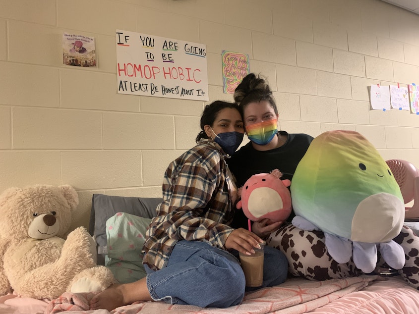 caption: Lia Harper(left) and her roommate hangout during the sit-in. Harper is currently in a play on campus, and says when she's not in class or performing, she's at the sit-in. "Your employer should have no right to know what you're doing in your house and your own sheets," Harper said.