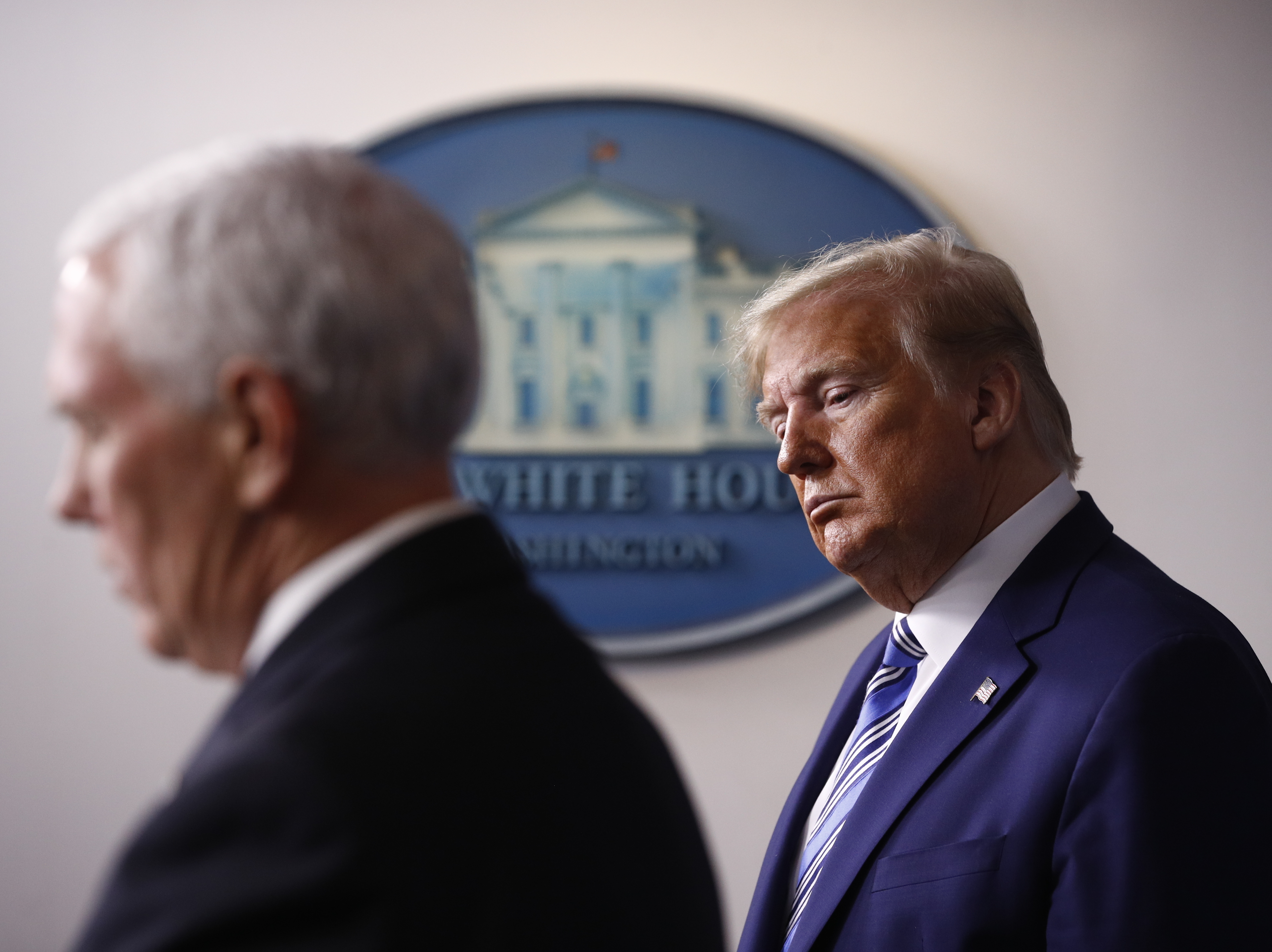 caption: President Trump listens as Vice President Mike Pence speaks during a coronavirus task force briefing at the White House in April.