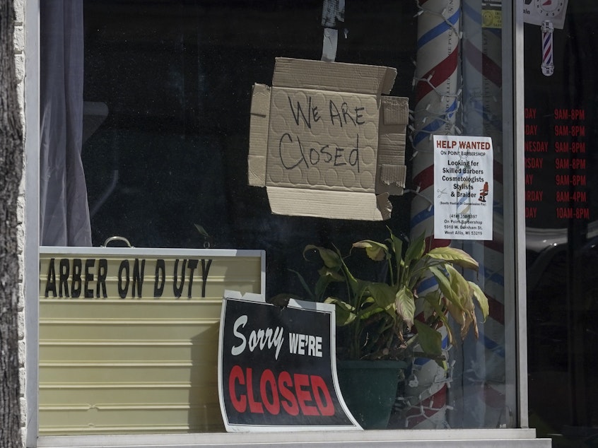 caption: Closed signs are seen Wednesday in businesses in Milwaukee. The coronavirus pandemic has left millions out of work.