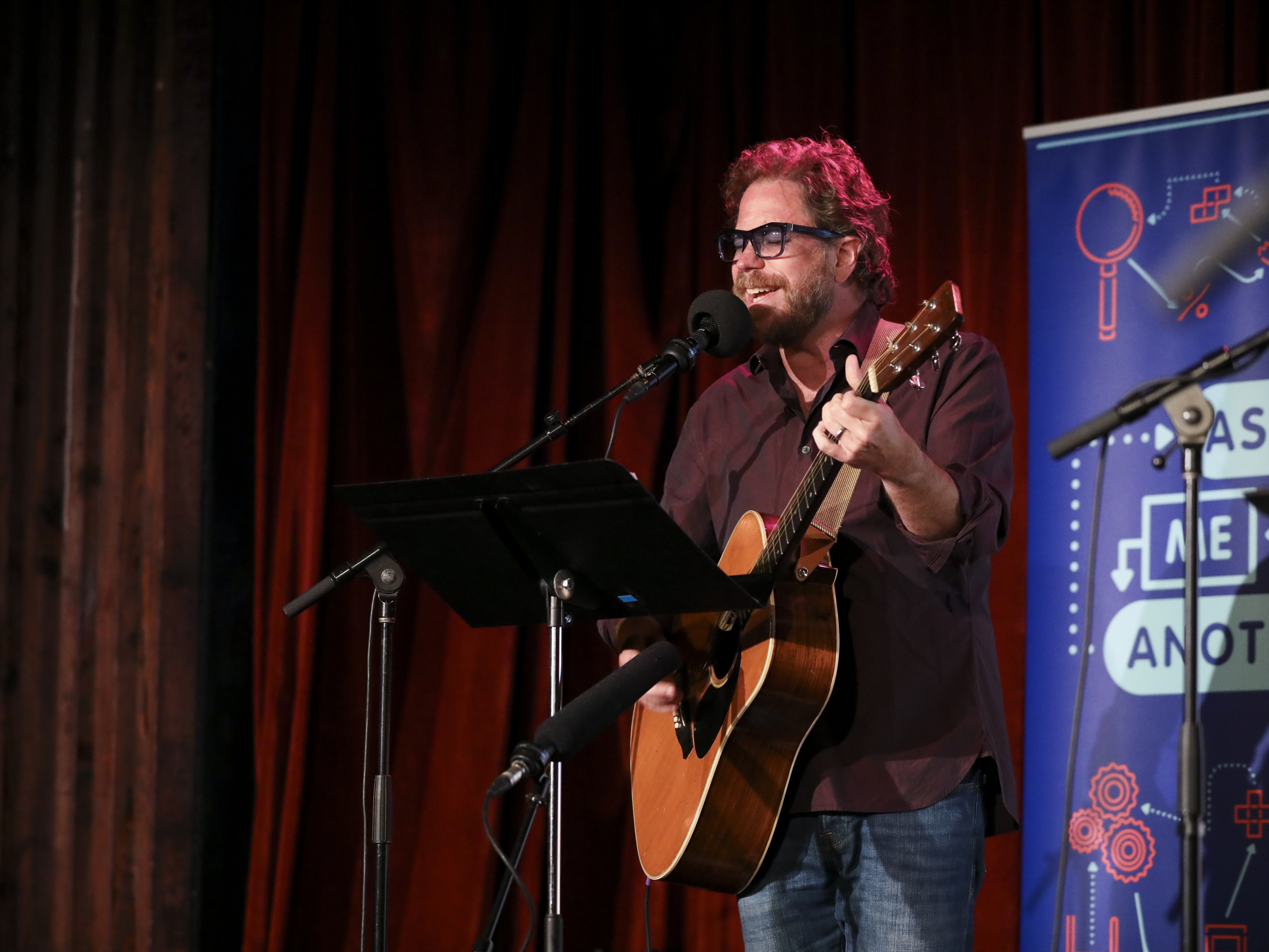 caption: House musician Jonathan Coulton leads a music parody game on <em>Ask Me Another</em> at the Bell House in Brooklyn, New York.